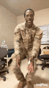 a man in a military uniform is smiling and holding something