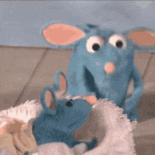 a couple of stuffed animals are sitting next to each other on a bed .