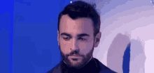 a man with a beard is wearing a black suit and turtleneck .