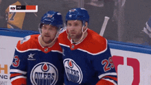 two edmonton oilers players are standing next to each other on the ice