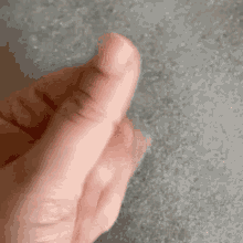 a close up of a person 's thumb on a concrete surface .
