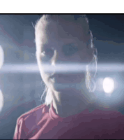 a close up of a woman 's face in a dark room with light coming out of her eyes