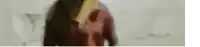 a blurry picture of a woman in a red shirt standing in front of a wall .