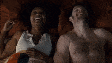 a man and a woman are laying on a bed together