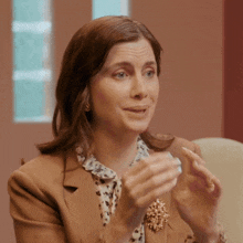a woman wearing a brown jacket and a leopard print shirt