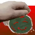 a person is holding a christmas ornament with a smiley face on it .
