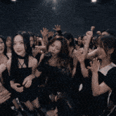 a group of young women are dancing in a dark room