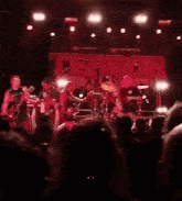 a man playing a guitar on stage in front of a banner that says ter