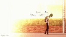 a man with a backpack is walking down a sidewalk with a brick wall in the background .