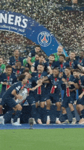 a group of soccer players holding a trophy in front of a sign that says paris