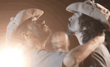 two men in cowboy hats are standing next to each other .