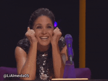 a woman sitting in front of a purple microphone with the hashtag lialmeida05 on the bottom