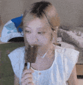 a woman wearing earbuds is eating a chocolate bar