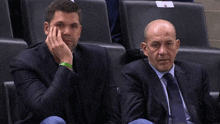 a man in a suit has a green wristband that says no