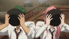 a man and a woman are covering their faces with a bowl
