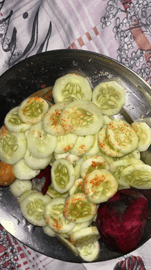 a plate of sliced cucumbers with spices on them on a table