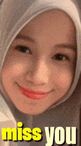 a woman wearing a hijab is smiling and the words miss you are behind her