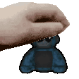 a pixelated image of a hand holding a small blue teddy bear .