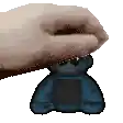 a pixelated image of a hand holding a small blue teddy bear .
