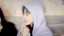 a girl in a purple hoodie is smiling while sitting next to another girl in a car .