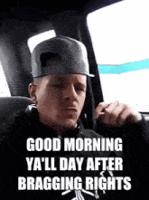a man wearing a baseball cap is sitting in a car with the words good morning ya 'll day after bragging rights