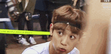 a young man wearing a headband is making a face