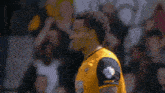 a soccer player in a yellow jersey with the word land on the sleeve
