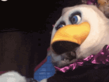 a mascot with a yellow beak and blue eyes