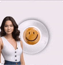a woman stands next to a cup of coffee with a smiley face drawn on it