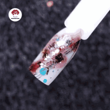 a close up of a nail with a nail polish brush and a watermark that says nails inspiration