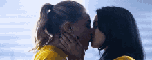 two women are kissing each other in a room .
