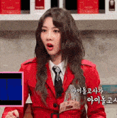 a woman wearing a red jacket and tie with korean writing