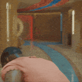 a man in a pink shirt is pointing his finger at the camera