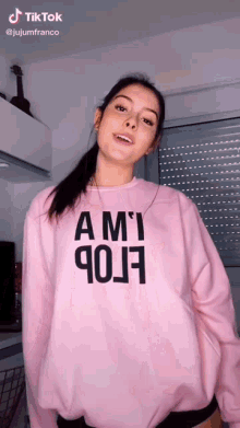 a woman is wearing a pink sweatshirt that says ami 90j7