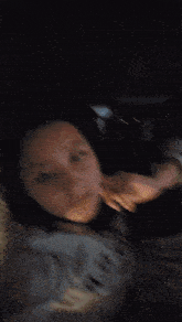 a blurry picture of a woman 's face with a few letters on the wall behind her