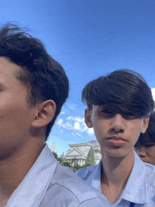 a group of young men are standing in front of a blue sky