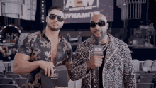 two men standing next to each other in front of a sign that says aew