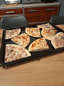 a tray of pizzas with various toppings on them
