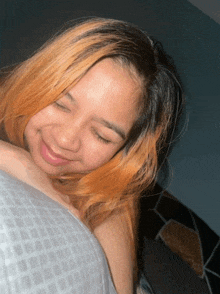 a woman with orange hair is smiling while laying on a bed