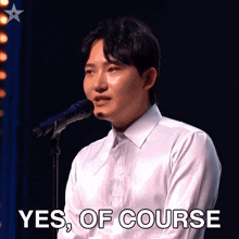 a man singing into a microphone with the words " yes of course " written below him