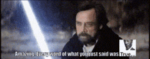 a man with a beard says " amazing " in front of a light saber
