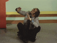 a man in a suit and tie is sitting on the floor