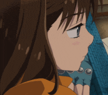 a close up of a girl 's face with a blue glove on her hand