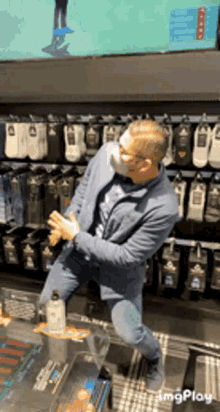 a man wearing a mask is dancing in front of a wall of socks