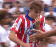 a man in a red white and blue striped shirt with the word atletico on the front