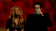 a man and a woman are blowing bubbles in front of a red background ..
