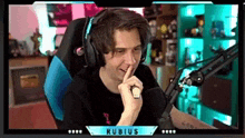a man wearing headphones and a microphone is sitting in a chair .