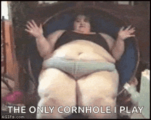 a very fat woman is sitting in a chair with her legs crossed .