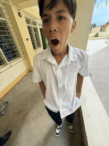 a boy in a white shirt with his mouth wide open