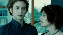 a man and a woman are looking at each other in a dark room